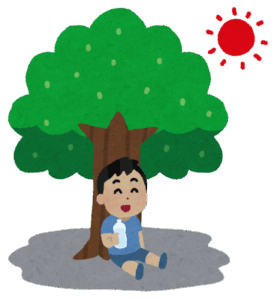 暑い日に日陰で一休みして水分補給をしている男の子